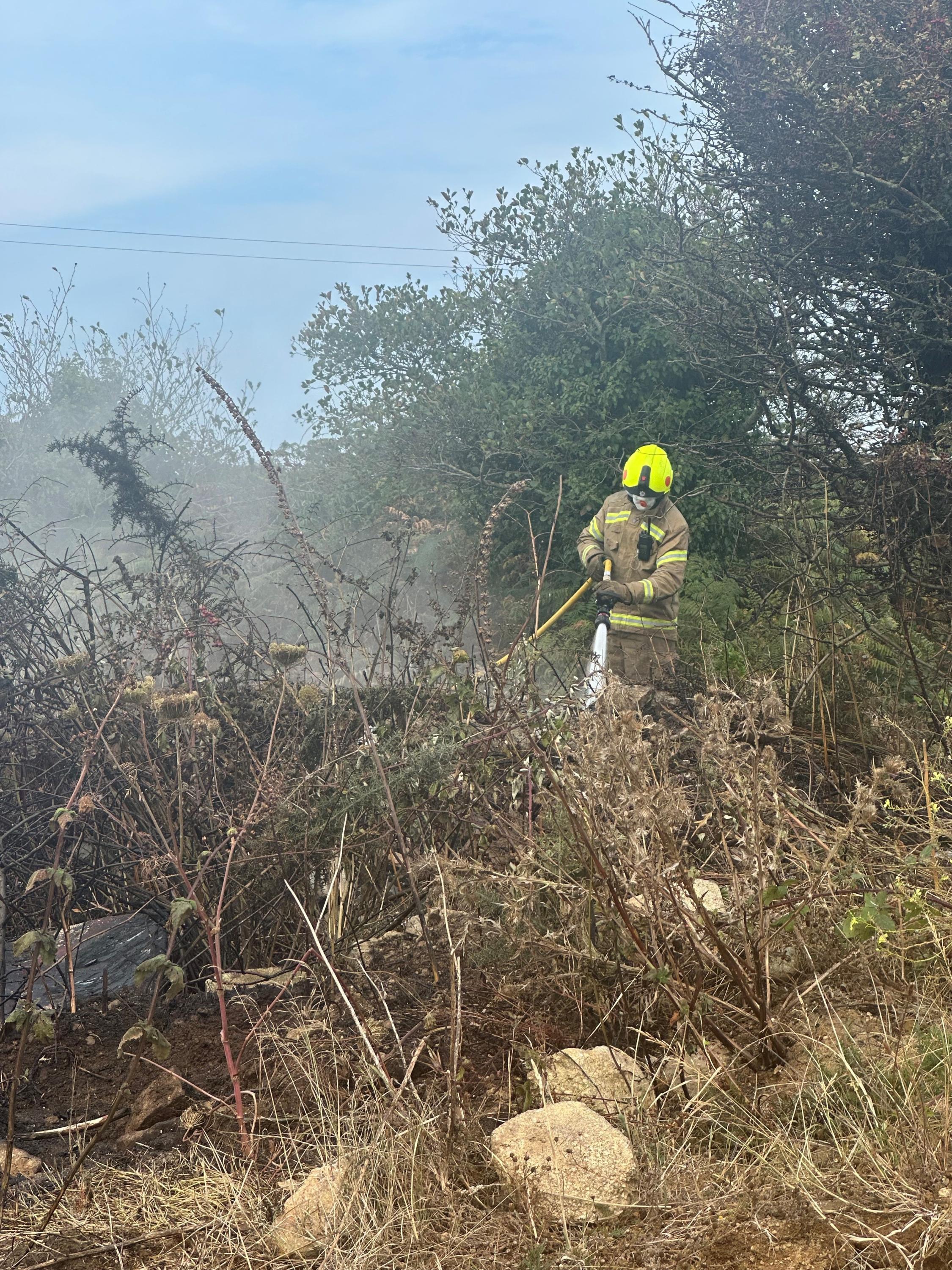 A firefighter works to extinguish areas left smouldering after the fire had been contained on St Marys on Sunday 24 August 2025.