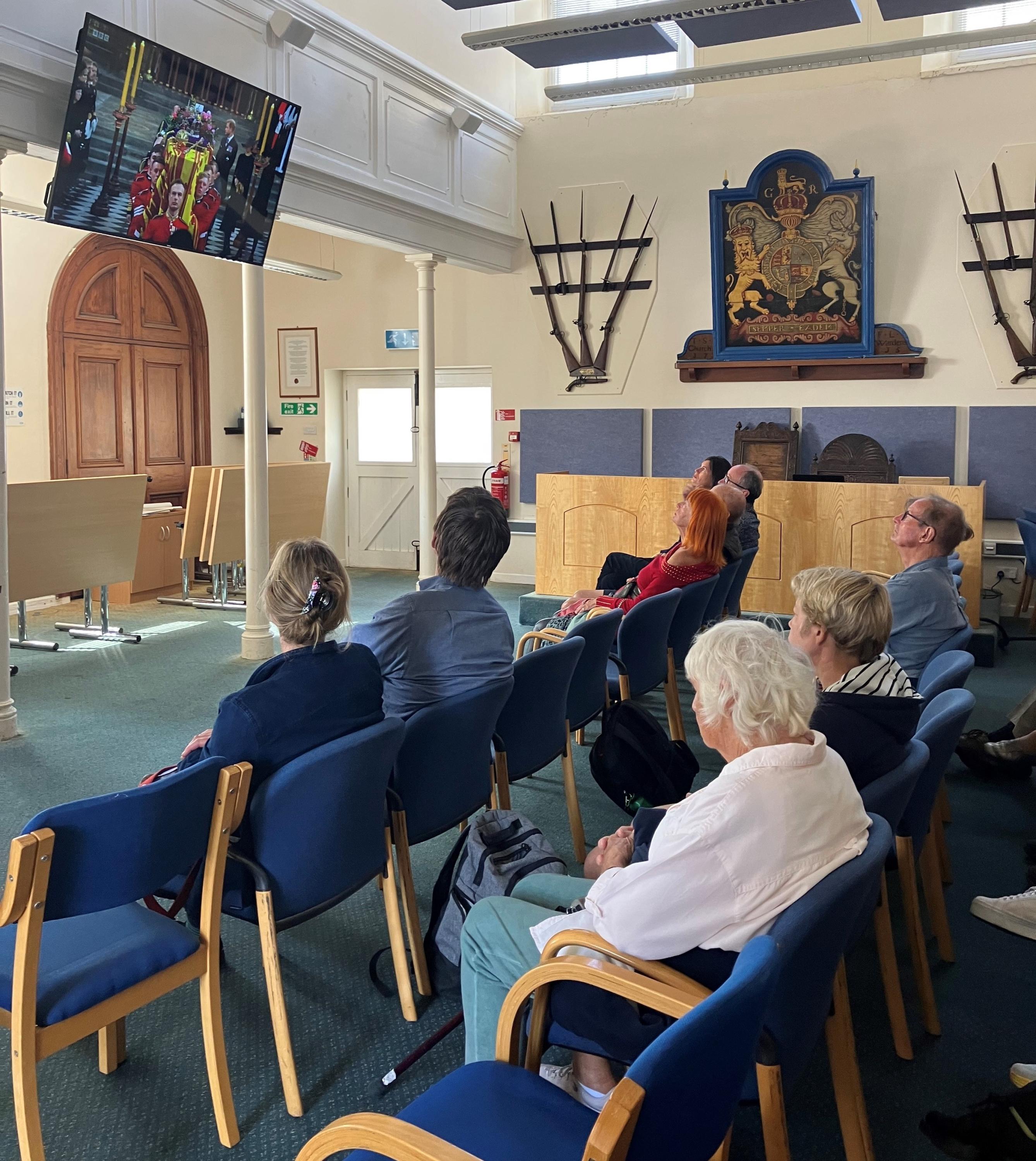 Image of people watching the State Funeral of Queen Elizabeth II at the Wesleyan Chapel on St Mary's