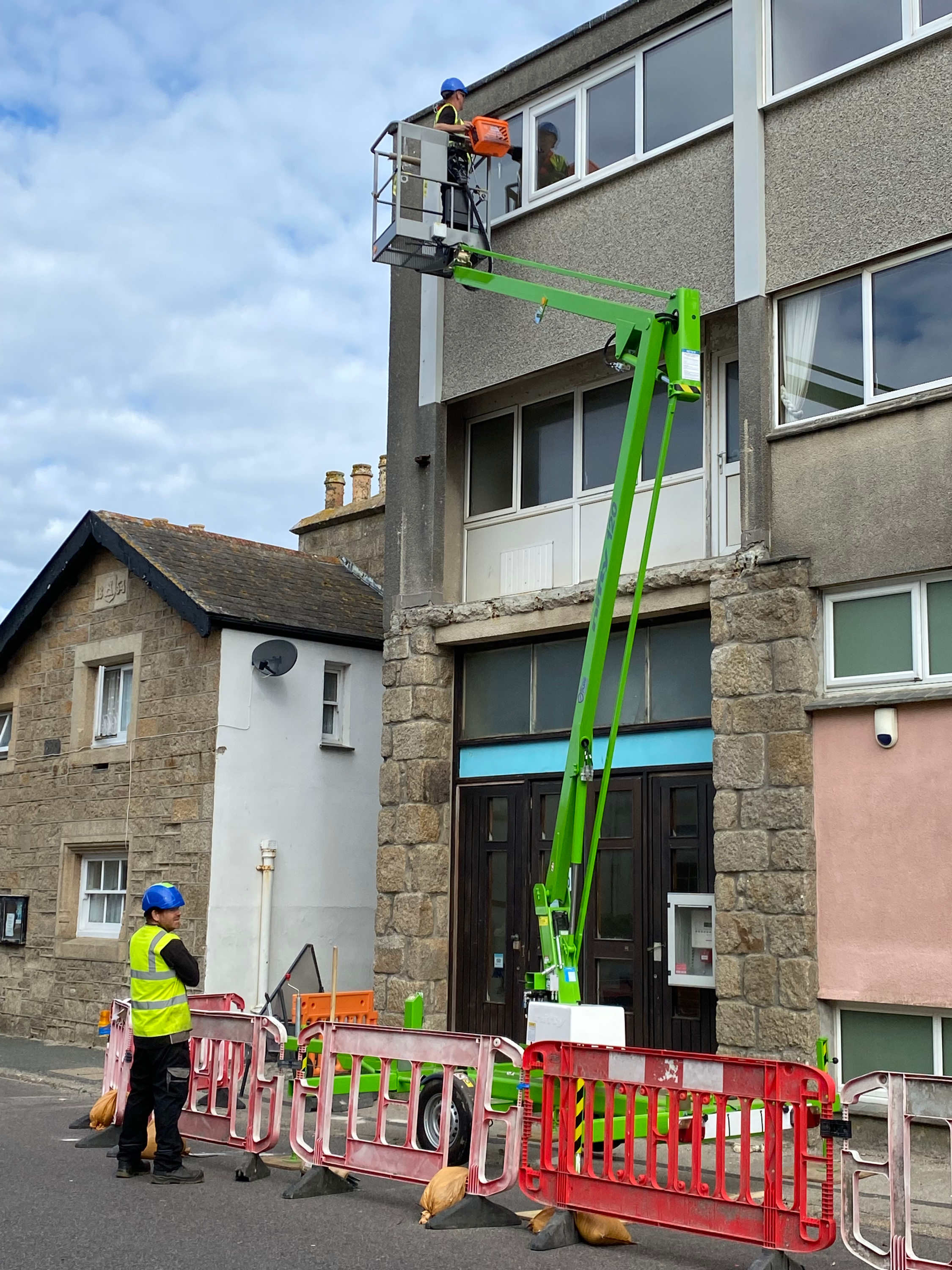 Council employees carrying out work on the site of the old museum using a cherry picker.